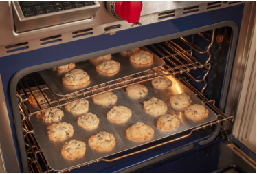 Un 4 dont la porte est ouverte, on peut y voir des biscuits sur une plaque de cuisson.