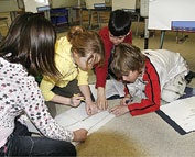 A group of students are working on the floor.