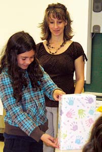 A student examines the box in the shape of a rectangular prism